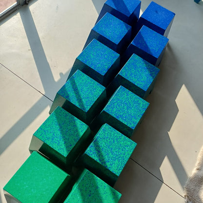A set of twelve cube-shaped stools arranged in two rows,. 