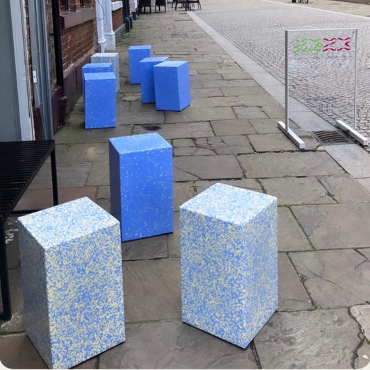 A street scene with several blue and white speckled cube stools made in ecopixel recycled plastic. Courtesy @2323Coffe Sheffield
